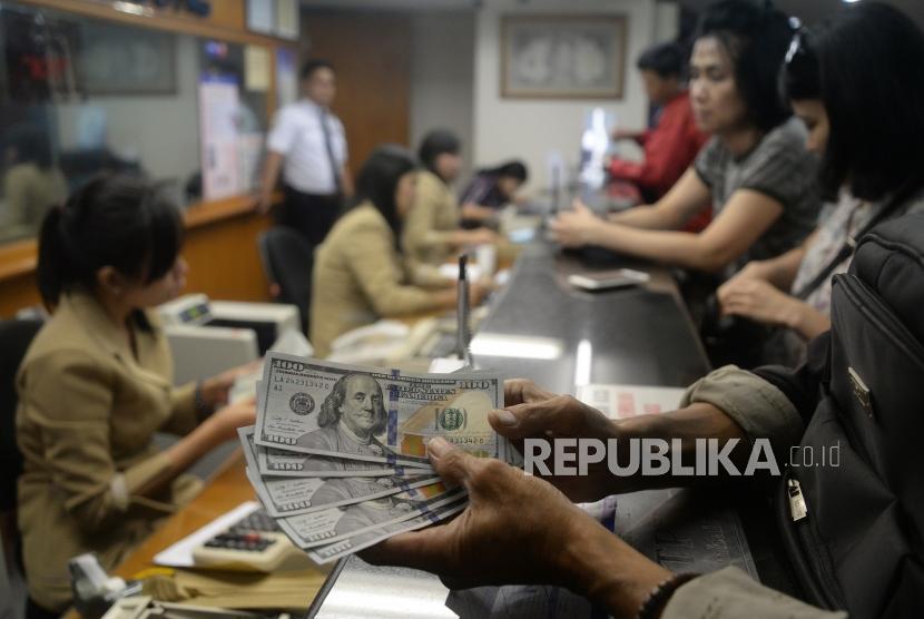 Rupiah Masih Terus Melemah. Pengunjung melakukan penukaran mata uang asing di jasa penukaran uang Ayu Masagung, Jakarta, Senin (23/4).