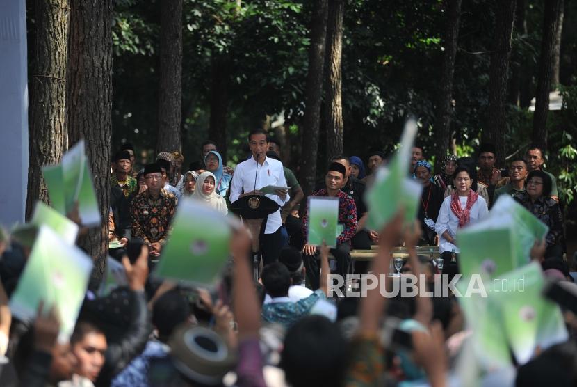 Presiden Joko Widodo menyerahkan Surat Keputusan (SK) izin Permanfaatan Hutan Perhutanan Sosial (IPHPS) di Wana Wisata Pokland Haurwangi, Kabupaten Cianjur, Jumat (8/1).