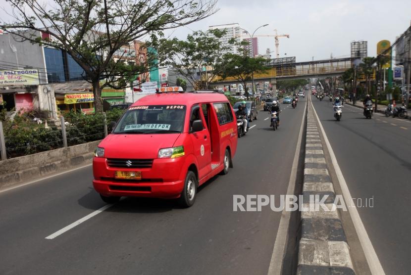 Angkutan kota (angkot) melintas di jalur cepat Jalan Margonda Raya, Kota Depok, Jawa Barat, Jumat (2/2).