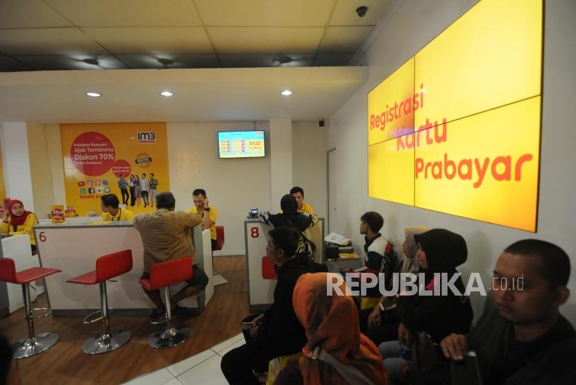 Warga mengantri untuk melakukan registrasi ulang kartu SIM prabayar di Galeri Indosat. Kebijakan registrasi ulang ini berdampak positif kepada kinerja keuangan emiten telekomunikasi.