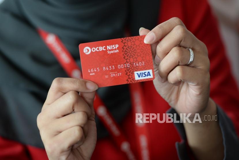  Petugas menunjukan kartu debit OCBC NISP Syariah. Bank OCBC NISP resmi meluncurkan Tabungan Emas.