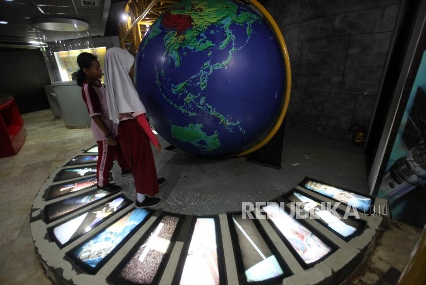 Sejumlah siswa Sekolah Dasar Peninggalan 04 Ciledug Tangerang (SD) mengamati alat peraga tata surya saat berkunjung ke Planetarium Jakarta, Kamis (8/11).