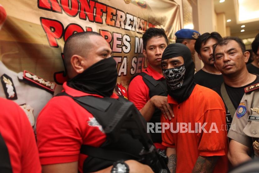 Petugas kepolisian memperlihatkan tersangka saat rilis kasus pembunuhan terhadap pensiunan TNI AL, Hunaedi, pada 5 April 2018 lalu di Polres Jakarta Selatan, Kamis (12/4).