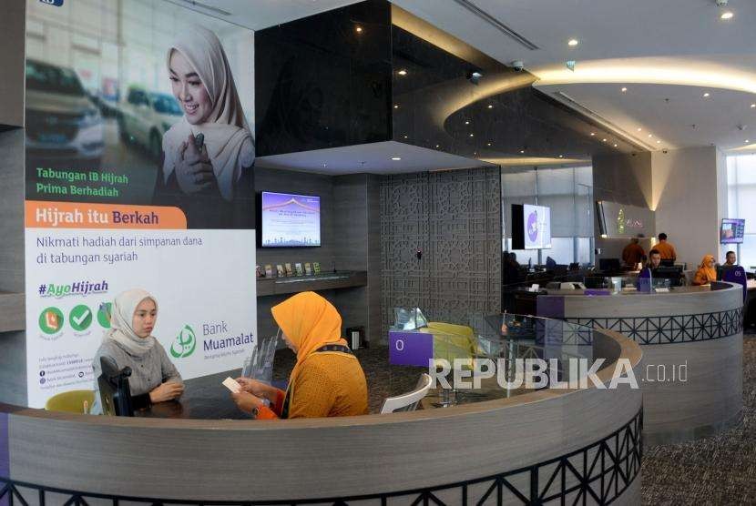 Petugas melayani nasabah di di kantor pusat Bank Muamalat, Jakarta, Selasa (9/10).