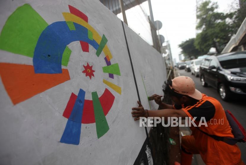 Petugas PPSU membuat mural tema Asian Games di Kawasan TB Simatupang, Jakarta, Rabu (16/5).