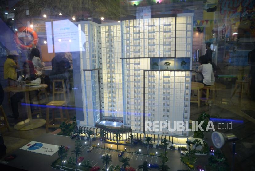 Penjaga stan menjelaskan tentang harga rumah dan fasilitasnya kepada calon konsumen saat pameran perumahan di Jakarta, Ahad (13/5).