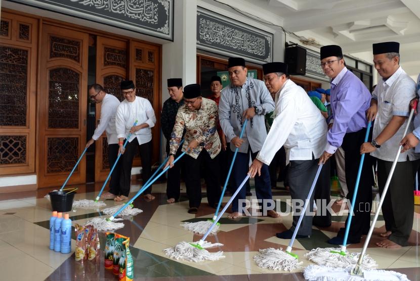 Wakil Ketua Dewan Masjid Indonesia Syafruddin saat mengepel masjid pada acara bersih-bersih masjid di Masjid Al-Mabrur, Asrama Haji Pondok Gede, Jakarta, Ahad (28/4).