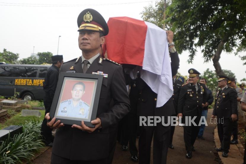 Anggota kepolisian membawa foto dan peti jenazah saat pemakaman korban jatuhnya pesawat Lion Air PK-LQP, AKBP Sekar Maulana di TPU Karet Bivak, Jakarta, Kamis (8/11).