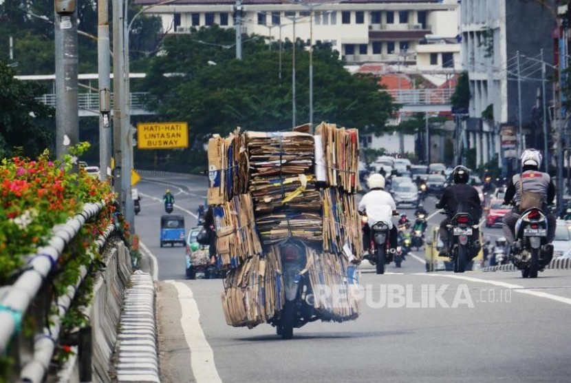 Sebuah sepeda motor dengan bermuatan tumpukan kardus bekas melintas di kisaran fly over Senen Jakarta, Selasa (4/7). Membawa barang dengan kapasitas berlebih pada sepeda motor dapat membahayakan dipengendara dan pengguna jalan lainnya. Foto: darmawan.