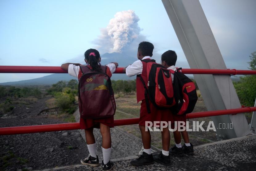 Erupsi Magmatik Masih Terjadi. Anak sekolah melihat erupsi magmatik Gunung Agung dari Kubu, Karangasem, Bali, Selasa (28/11).