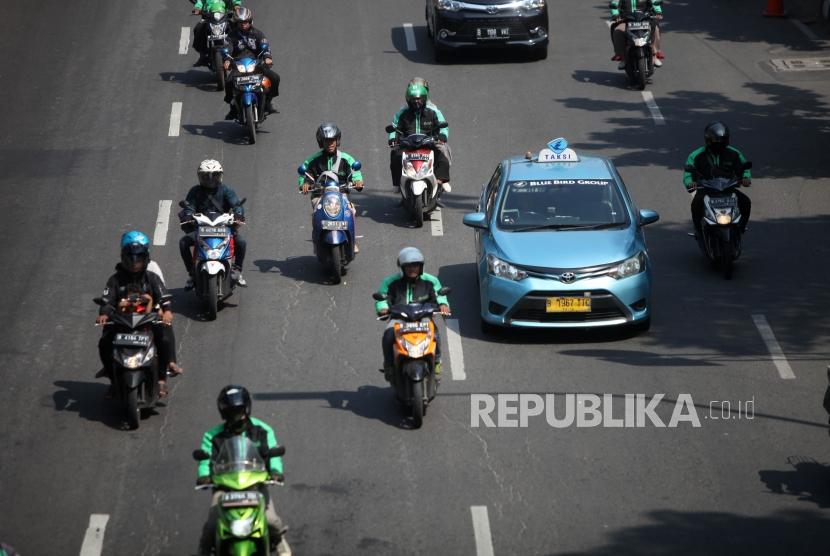 Sejumlah ojek online mengantarkan penumpang di Kawasan Tebet, Jakarta, Jumat (27/7).