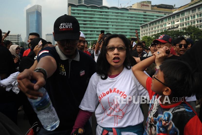 Susi Ferawati (white t-shirt) and her son walk through a crowd of people from the opposite political axis at Car Free Day, Jakarta, on Sunday (April 29).