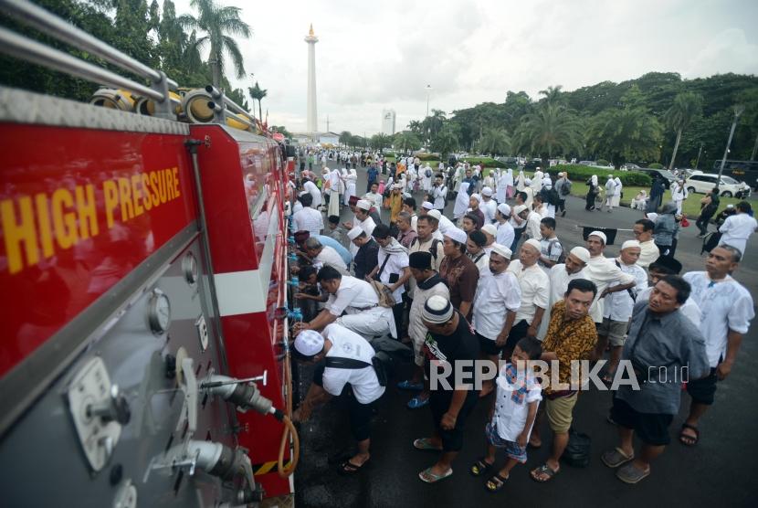 Munajat 212. Sejumlah umat muslim mengambil air wudhu untuk melaksanakan shalat Maghrib berjamaah di Monas, Jakarta, Kamis (21/2).