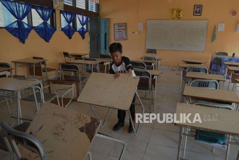 Aktivitas Pendidikan : Siswa SMP Negeri 6 mengangkat meja belajar saat melihat kondisi sekolahnya di Jalan Dewi Sartika, Palu, Sulawesi Tengah, Senin (8/10).