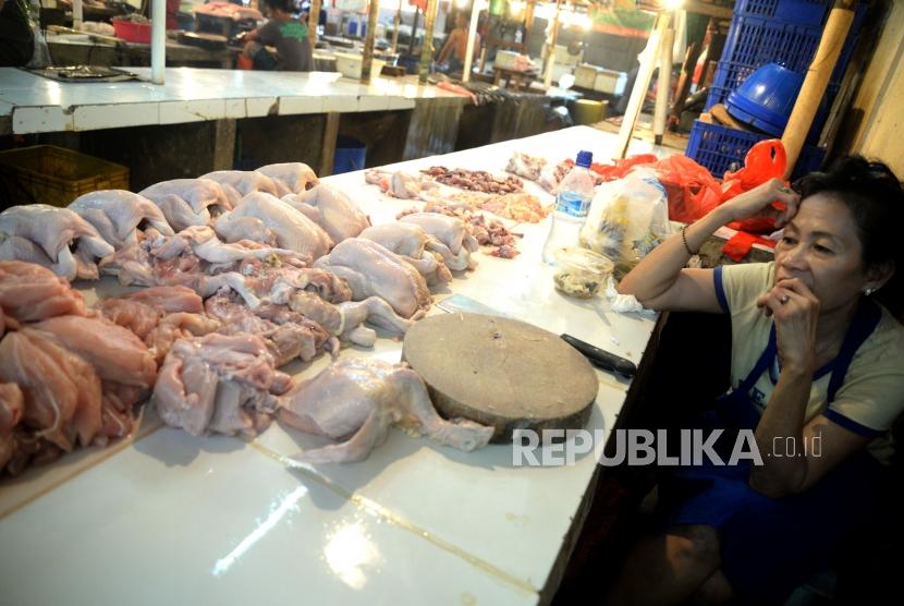 Pedagang melayani pembeli daging ayam