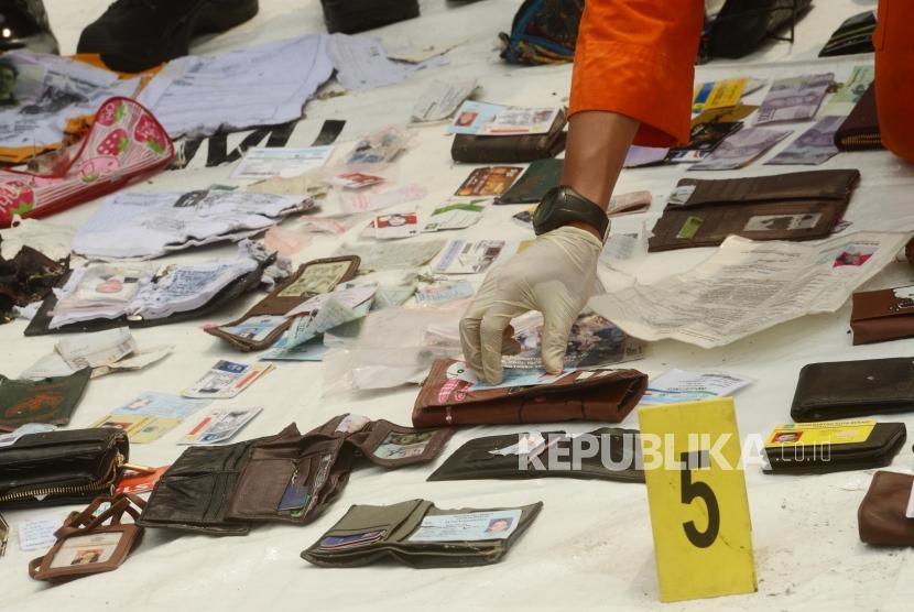 Sejumlah petugas Basarnas merapikan kartu identitas yang diduga milik para korban jatuhnya pesawat Lion Air JT610 di Dermaga JICT 2 Pelabuhan Tanjung Priok, Jakarta, Selasa (30/10).