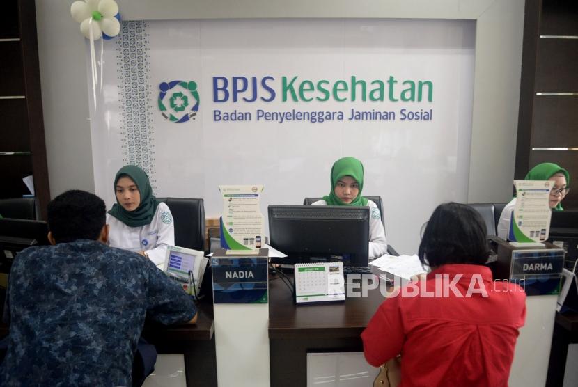 Petugas Badan Penyelenggara Jaminan Sosial (BPJS) Kesehatan melayani warga di kantor BPJS Kesehatan Cabang Jakarta Selatan, Senin (2/9).