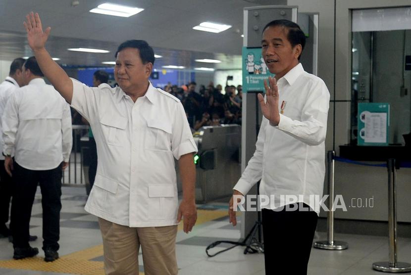 Presiden Joko Widodo dan Ketua Umum Partai Gerindra Prabowo Subianto melambaikan tangannya saat tiba di Stasiun MRT Lebak Bulus, Jakarta, Sabtu (13/7).