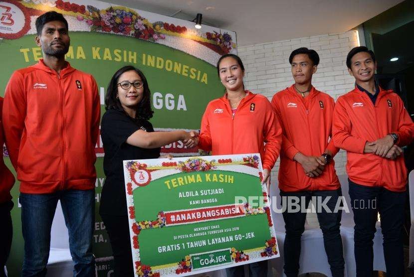 Chief of Corporate Affairs Go-Jek Indonesia Nila Marita memberikan apresiasi kepada perwakilan atlet peraih medali emas Aldila Sutjiadi di Jakarta, Kamis (6/9).