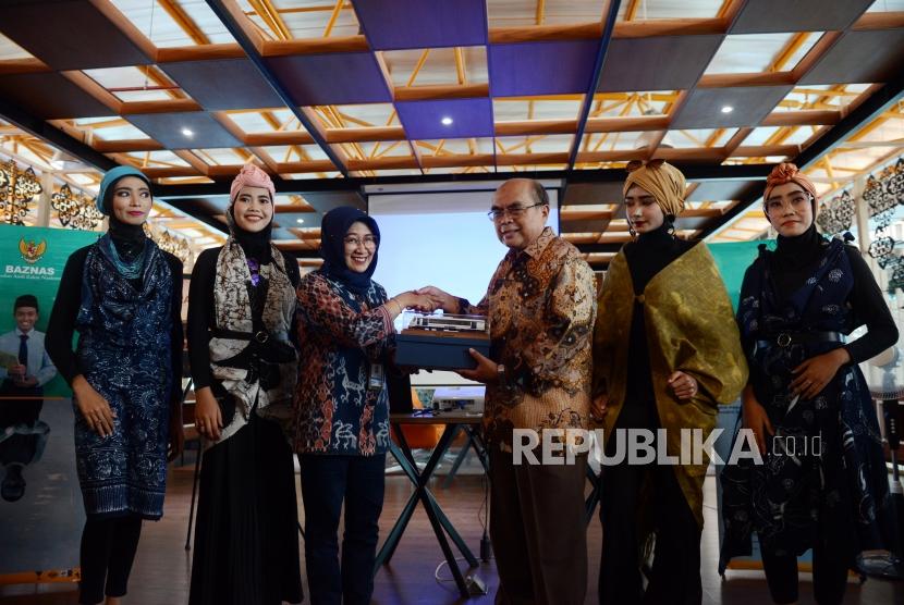 Ketua Badan Amil Zakat Nasional (Baznas) menerima cinderamata dari Direktur Administrasi dan Keuangan PT Railink Indah Suryandari didampingi sejumlah model sebelum acara peragaan busana di Stasiun BNI City, Jakarta, Kamis (2/5).