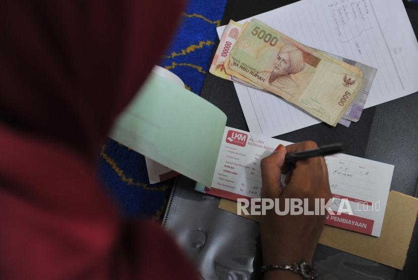 Bank Wakaf Mikro : Petugas menerima pembayaran angsuran nasabah Bank Wakaf Mikro (BWM) Almuna Berkah Mandiri saat halaqoh mingguan di salah satu rumah warga di Krapyak, Yogyakarta, Sabtu (5/5).