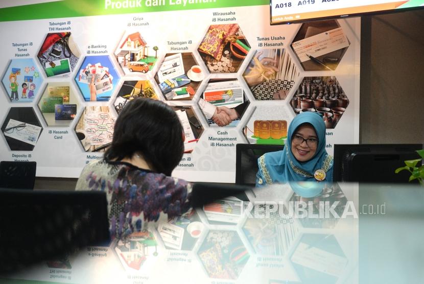 Target Buku III. Petugas melayani transaksi nasabah di kantor layanan BNI Syariah, Jakarta, Selasa (3/7).