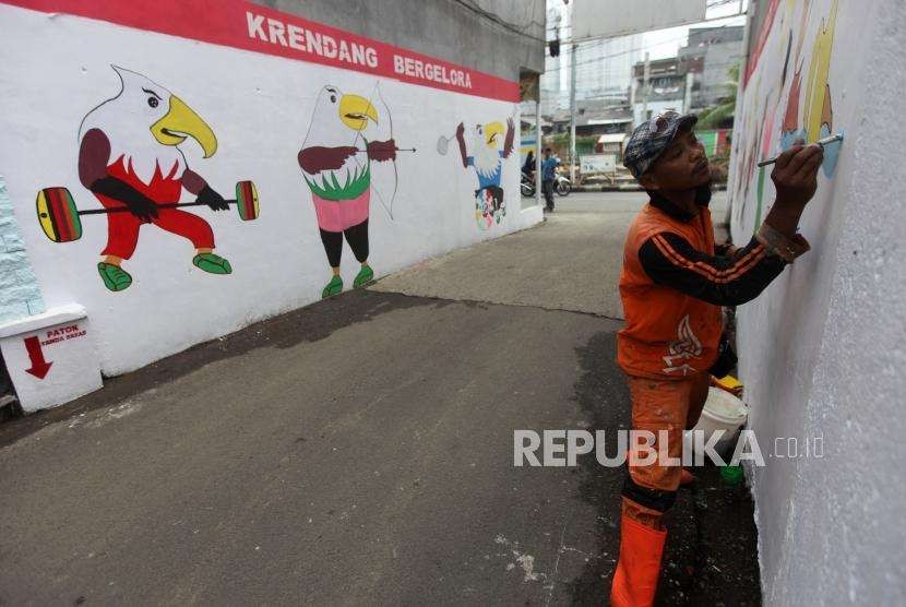 Petugas PPSU membuat mural bertema Asian Para Games 2018 di Kelurahan Krendang, Tambora, Jakarta, Jumat (21/9).