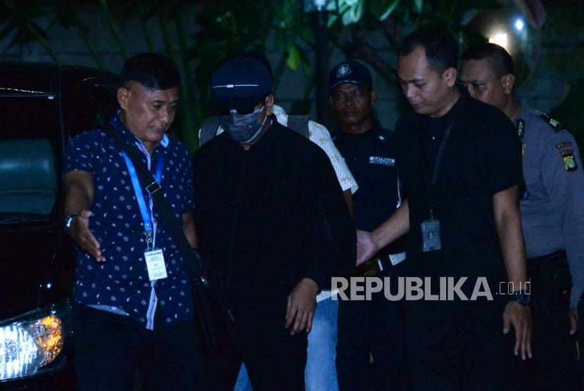 Ketua Umum Partai Persatuan Pembangunan (PPP) Romahurmuziy (mengenakan masker dan bertopi)  digiring petugas setibanya di gedung KPK, Jakarta, Jumat ( 15/3).