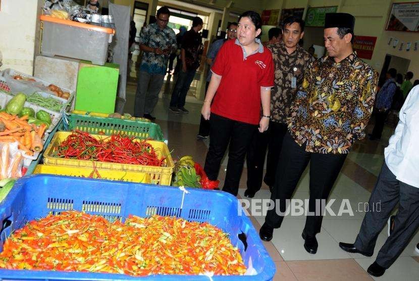 Menteri Pertanian Amran Sulaiman (kanan) saat meninjau Toko Tani Indonesia (TTI), Pasar Minggu, Jakarta, Jumat (18/5).