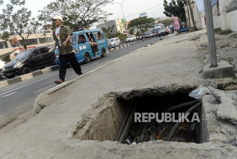 Pejalan kaki menghindari trotoar yang bolong di Jalan Margonda Raya, Depok, Jawa Barat, Rabu (14/8).