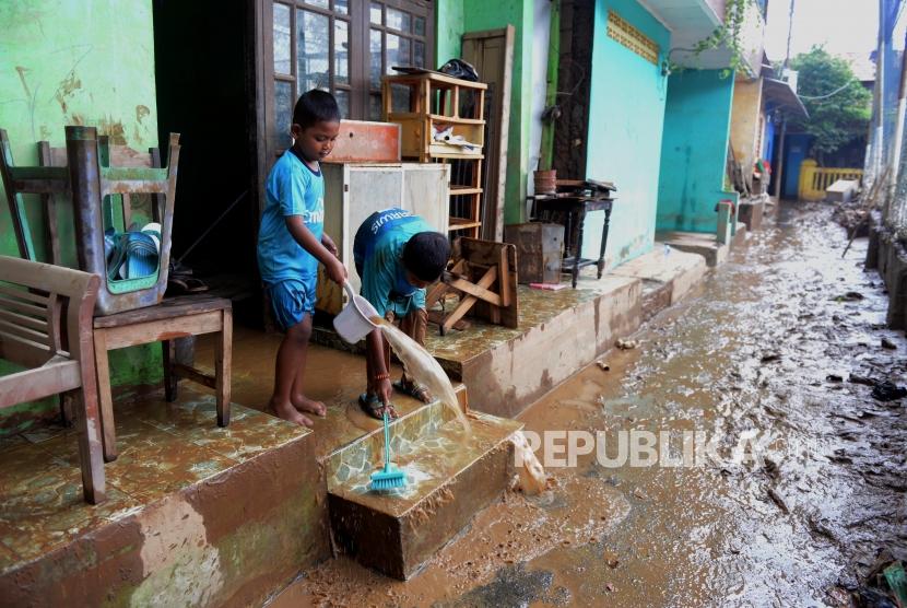 Anak-anak saat membersihkan lumpur sisa banjir di kawasan Rawajati, Jakarta, Ahad (28/4).