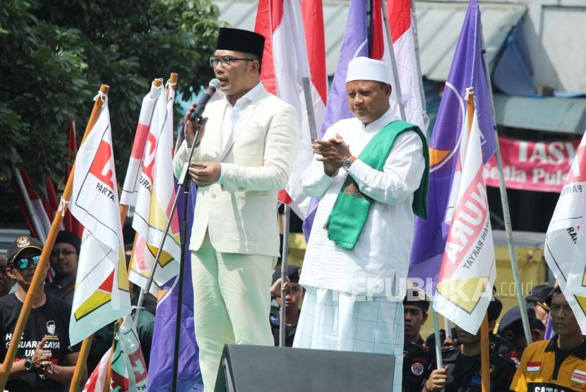 Pasangan calon gubernur dan wakil gubernur Jawa Barat Ridwan Kamil (kiri) dan Uu Ruzhanul Ulum menyampaikan orasi pilotik di depan massa pendukungnya di pelataran parkir Stadion Sidolig, Kota Bandung, Selasa (9/1).