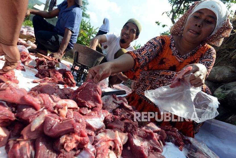 Sejumlah warga membungkus daging sapi yang telah dikurbankan di Posko Pengungsian Desa Kekait, Gunungsari, Lombok Barat, Nusa Tenggara Barat, Rabu (22/8).