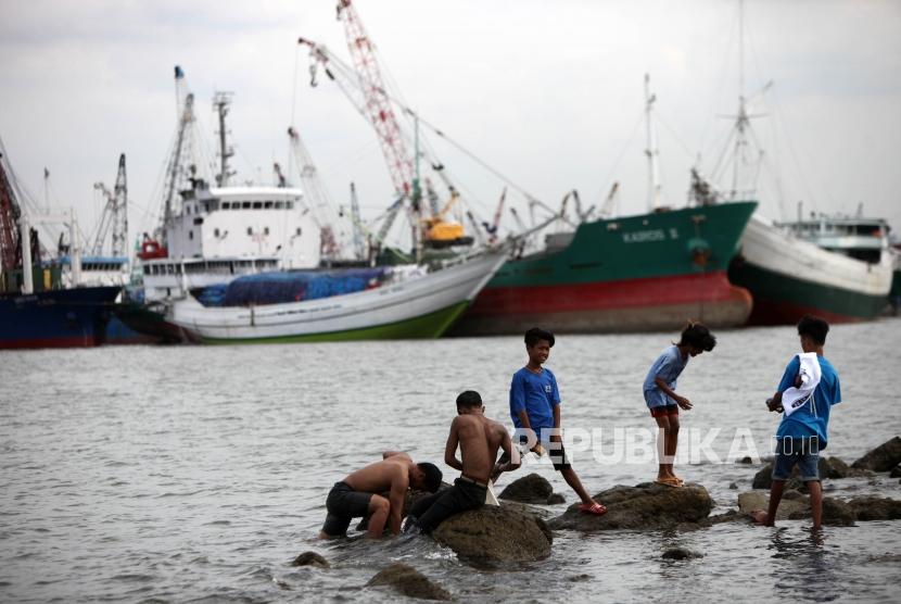 Seorang anak bermain dipesisir laut di Kawasan Muara Baru, Jakarta, Kamis (28/12).