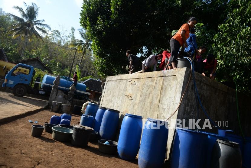 Kesulitan Air Bersih. Warga mengambil air saat pengiriman air bersih dengan tangki di Dusun Papringan, Tileng, Gunungkidul, Selasa (25/6/2019).