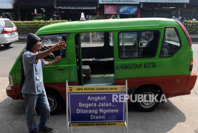 Sejumlah angkutan kota (angkot) menunggu penumpang di depan Stasiun Bogor, Kota Bogor, Jawa Barat, Ahad (13/5).