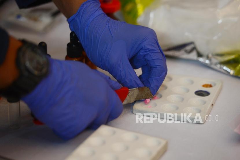 Sejumlah petugas melakukan uji laboratorium barang bukti saat konferensi pers pemusnahan narkoba di Gedung Promoter Polda Metro Jaya, Jakarta, Senin (18/2).