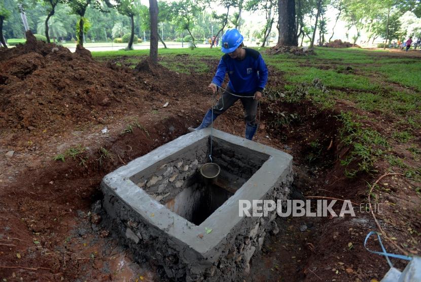 Sumur Resapan. Petugas Dinas Sumber Daya Air saat mengambil air dari sumur resapan yang sedang dibangun di kawasan Monas, Jakarta, Selasa (26/2).