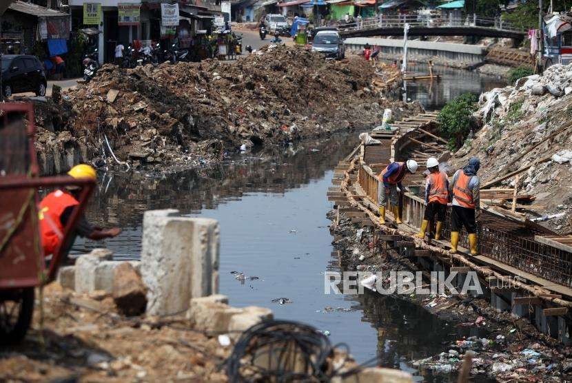 Pekerja menyelesaikan pembangunan turap di sepanjang Kali Grogol, Palmerah Barat, Jakarta, Rabu (5/9).