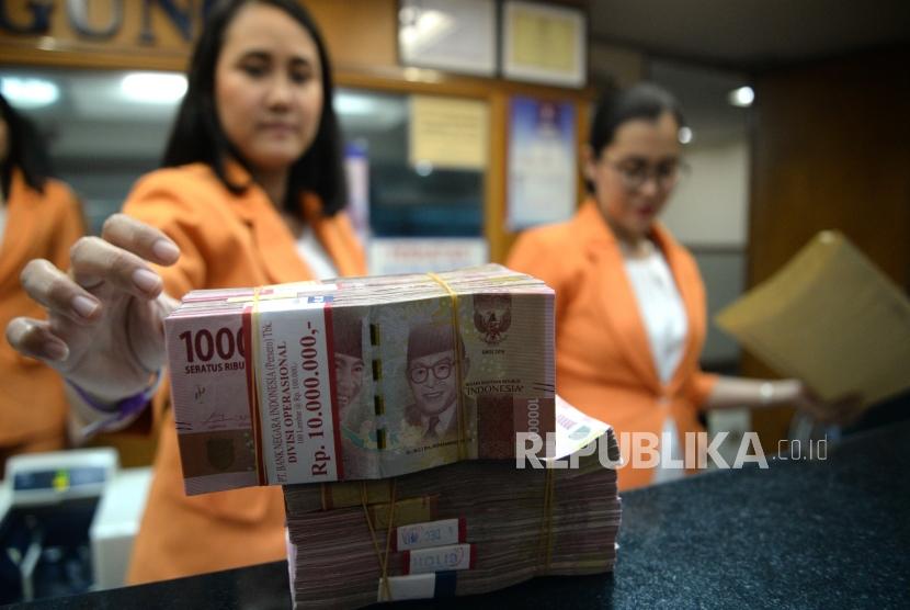 Transaksi Mata Uang Lokal. Petugas menghitung mata uang Rupiah di jasa penukaran uang, Jakarta, Senin (11/12).