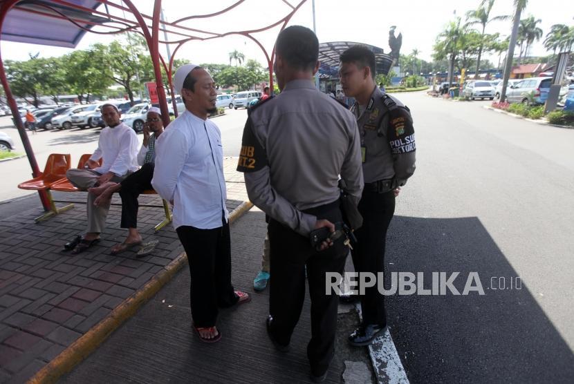 Pendukung Habib Rizieq berbincang dengan petugas polisi saat menunggu kedatangan Habib Rizieq di Bandara Soekarno-Hatta, Tangerang, Banten, Rabu (21/2).