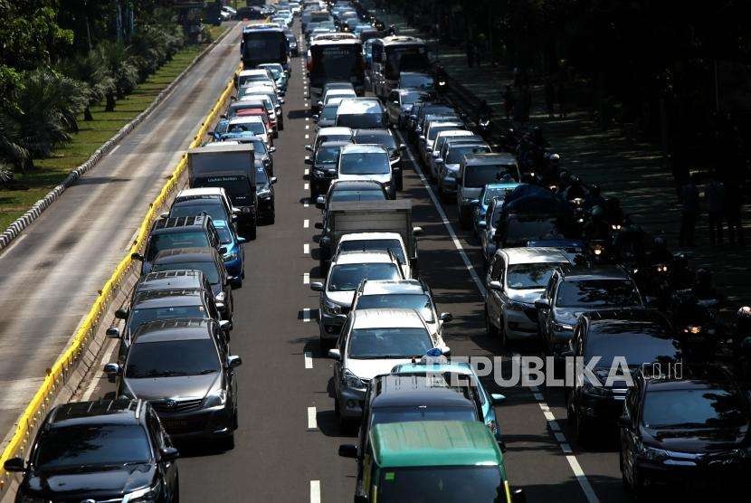 Antrean kendaraan yang melintas saat penerapan sistem ganjil genap di Jalan Medan Merdeka Barat, Jakarta, Senin (3/9).