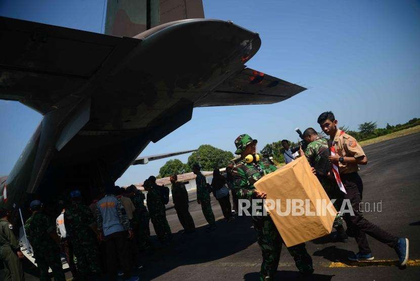 Anggota TNI  memindahkan   bantuan dan logistik  menuju mobil  saat tiba di lanud zam, Mataram,  Lombok, Nusa Tenggara Barat, Kamis (8/9).