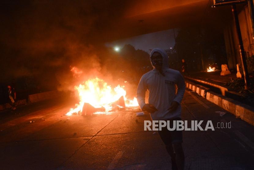 Massa Aksi Mahasiswa Indonesia berlari menghindari gas air mata saat aksi di depan kawasan Jalan Tol Dalam Kota Gatoto Soebroto, Jakarta, Selasa (24/9/2019).