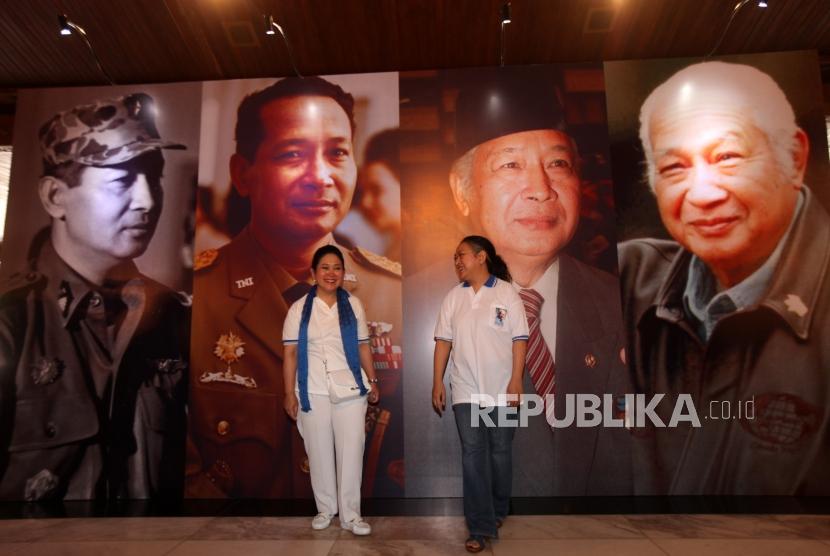Putri Alm Presiden kedua Indonesia Soeharto, Siti Hediati Hariyadi (kiri) bersama Siti Hutami Endang Adiningsih (kanan) berfoto bersama dilantar foto Soeharto saat meninjau pameran foto pada acara Bulan HM Soeharto di Taman Mini Indonesia Indah (TMII), Jakarta Timur, Ahad (11/3).