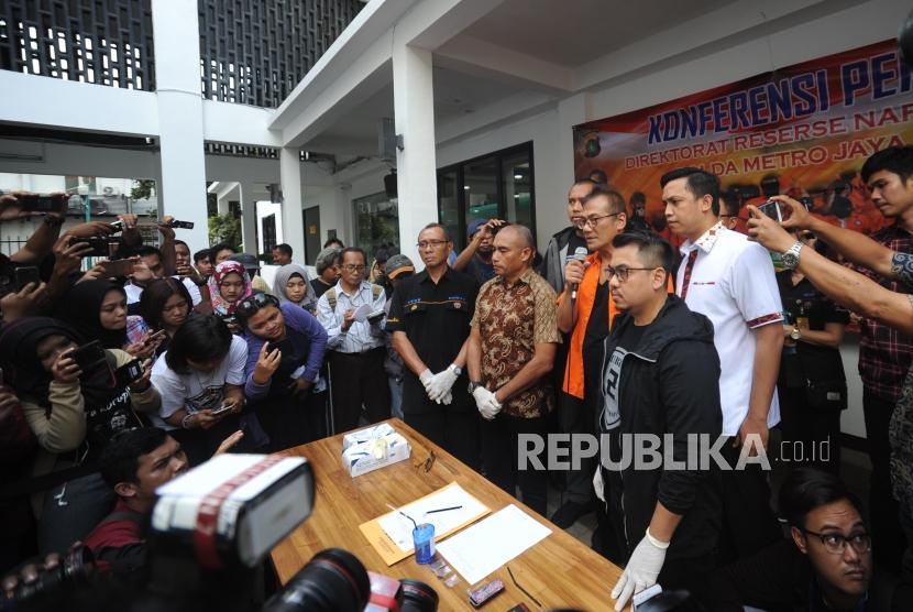 Tersangka kasus narkoba yang juga aktor senior Tio Pakusadewo (tengah) dihadirkan saat rilis kasus narkoba, di Polda Metro Jaya, Jakarta, Jumat (22/12).