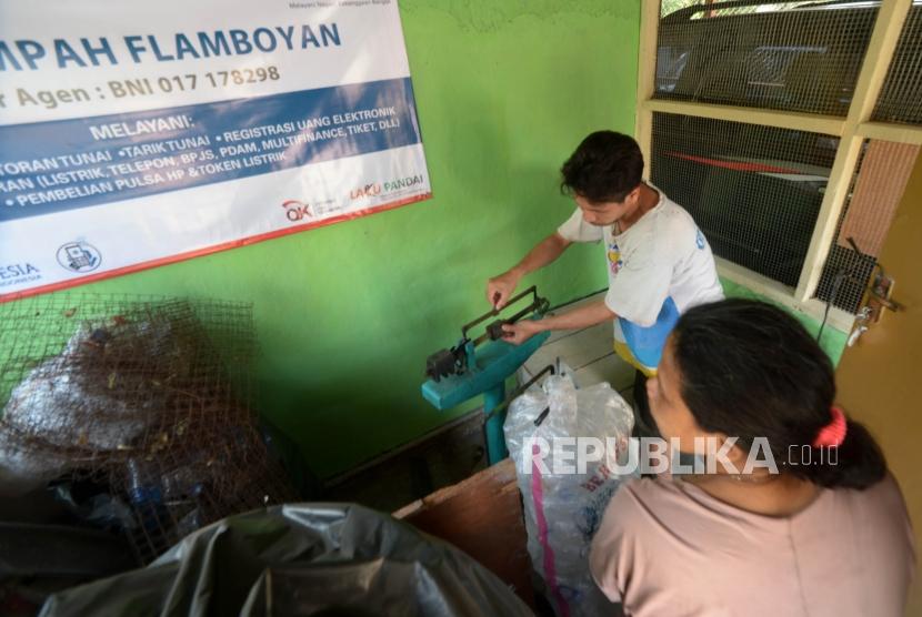 Umar petugas bank sampah menimbang sampah di bank Sampah Flamboyan, Jakarta, Senin (15/10).