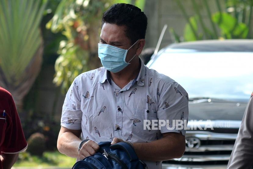 Kepala Kantor Imigrasi Kelas I Mataram Kurniadie (bermasker) digiring petugas saat tiba di Gedung KPK Merah Putih, Jakarta, Selasa (28/5).