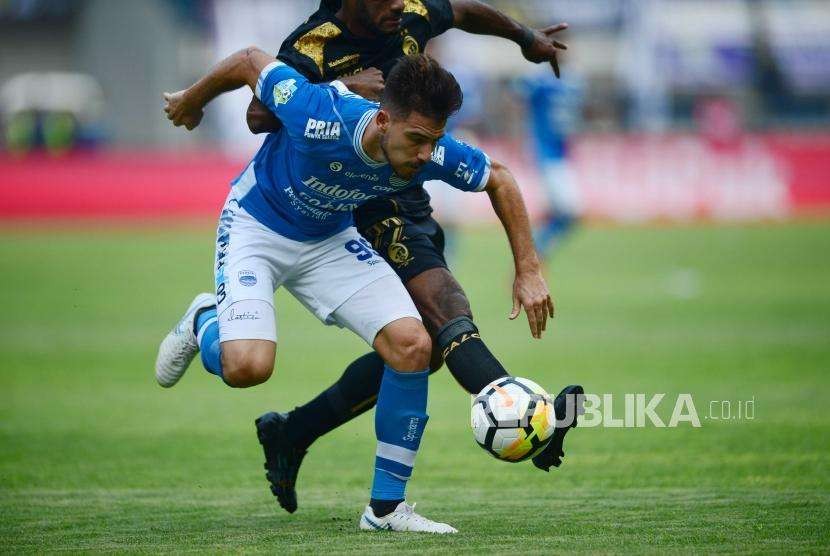 Striker Persib Jonathan Bauman diadang pemain Sriwijaya FC pada pertadingan Gojek Liga1 2018 di Stadion Gelora Bandung Lautan Api (GBLA) di Bandung, Sabtu (4/7).