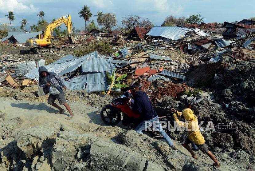 Warga menyelamatkan motornya saat proses evakuasi jenazah di Petobo, Palu, Sulawesi Utara, Rabu (3/10).